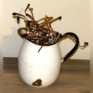 Small white and black antique metal pitcher with decor stem inside